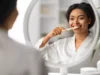 femme qui se brosse les dents devant un miroir